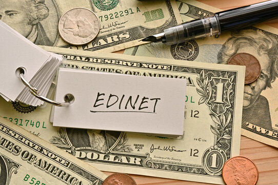 On top of the dollar bills on the table, there is a word book with the financial term EDINET written on it. It is an abbreviation for Electronic Disclosure for Investors' NETwork.