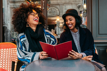 two Black women ihaving a great time at a restaurant