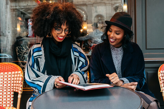 two Black women looking at a restaurant menu
