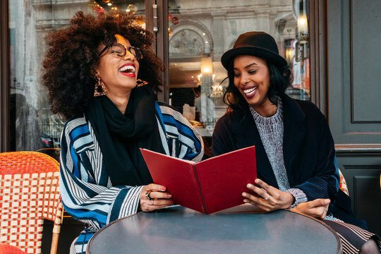 two Black women ihaving a great time at  a restaurant