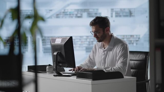 businessman working on computer at home office. Male professional typing on laptop keyboard at office workplace. Portrait of positive business man looking at laptop screen indoors