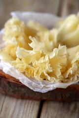 Tete de Moine cheese on a wooden surface.