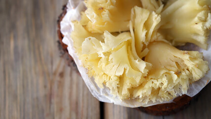 Tete de Moine cheese on a wooden surface.