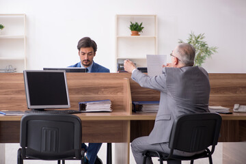 Two male employees working in the office