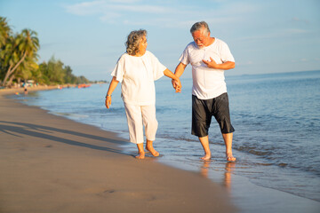 Family On Summer Beach Vacation, healthy older couple running on sea beach, Concept for .caring for the elderly, Caregiving to older persons and relations of the family to support elderly state
