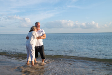 Family On Summer Beach Vacation, healthy older couple running on sea beach, Concept for .caring for the elderly, Caregiving to older persons and relations of the family to support elderly state