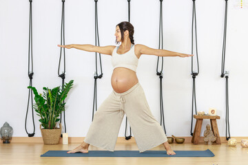 Pregnancy Yoga. Young woman practices yoga at home.