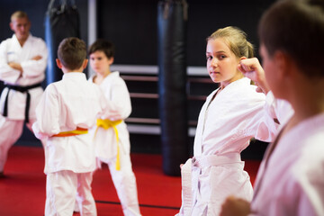 Fototapeta na wymiar Children sparring in pairs to practice new moves in karate class