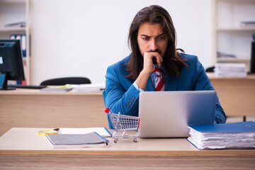 Young male employee in ecommerce concept in the office