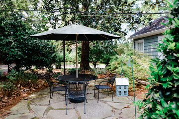 Obraz premium Backyard of a home with a patio table and unbrella and trees