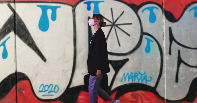 Young Businesswoman with ffp2 Mask Walking on Graffiti Background