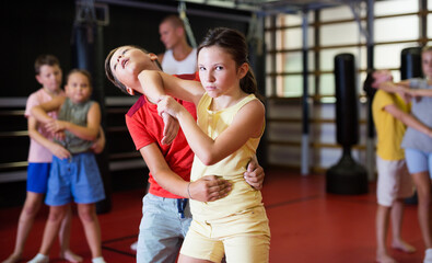 Girls and boys training chin strike on each other during group self-protection training.