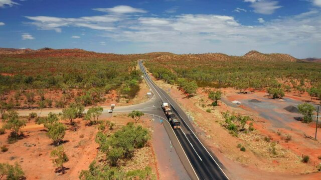 Road Train Driving Through Outback Landscape In Northern Territory Of Australia. aerial