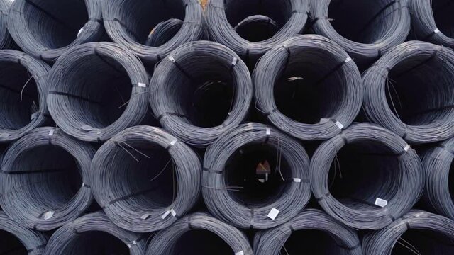 Metal wire rolls, outdoors at steel works, in sunny Goa, India - tracking shot