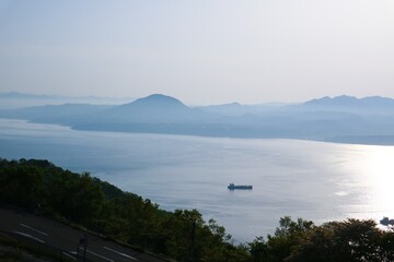 The morning scenery of the sea, sky, mountains, trees and small boats on a lake in Hokkaido, Japan gives a very refreshing feeling to relax.