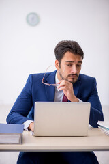 Young male employee unhappy with excessive work in the office