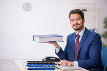 Young male employee unhappy with excessive work in the office