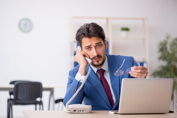 Young male employee sitting at workplace