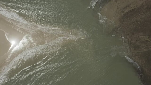 Arial View of island where two oceans meet. triangle shape of sand. waves coming from two sides on island