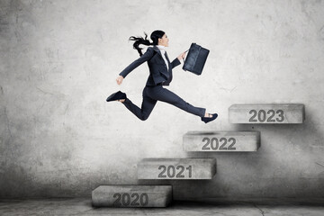 Female manager runs on stairs toward 2022 numbers
