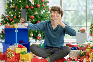 Caucasian man with casual cloth hold tablet and greeting action via online meeting during Christmas...
