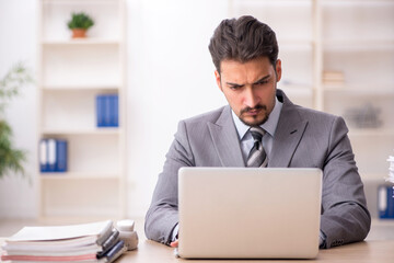 Young male employee unhappy with excessive work in the office