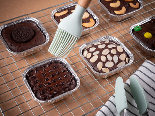 group of brownie cub cake in aluminium foil cup on sieve for placing snacks in the shop. food concept on photography image.