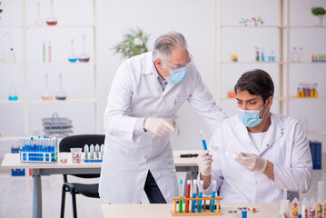 Two male chemists in drugs synthesis concept at the lab