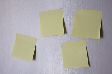 blank yellow note papers on wall 