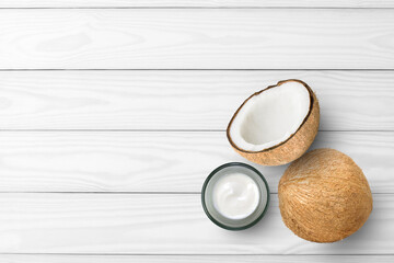 Fototapeta na wymiar Skin care cream natural product in glass jar with coconut fruit isolated on wooden table background. Organic cosmetic beauty and spa concept.Top view. Flat lay. Copy space for text.