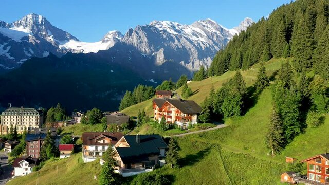 Drone shot of Murren, a traditional Walser mountain village in the Bernese Highlands of Switzerland. Flying over homes and hotels with mountains in the distance