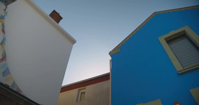 Building Exteriors With Flaglets On The Wall Against Bright Sky In Trentemoult Near Nantes In France. low angle, panning