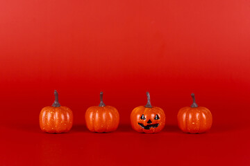 Happy pumpkins with smile on red background. Halloween and decoration concept. Front view and copy space