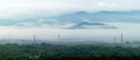 Fototapeta na wymiar Panorama aerial view transmission tower in green forest and beautiful morning smooth fog. Energy and environment concept. High voltage power poles. mae moh, lampang.