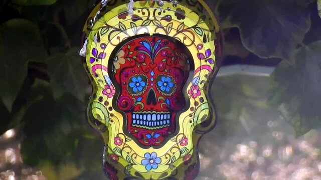 Hypnotic metal sugar skull decorative spinning  colourful garden ornament hanging from tree