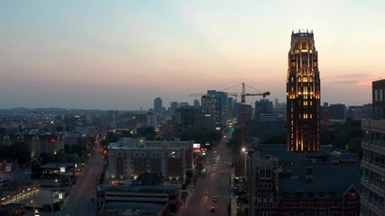Rising aerial of Vanderbilt University campus at dawn, dusk. Night lights illuminate city.