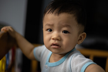 Portrait Adorable and happy 1 years old Chinese baby boy child relaxing in bed