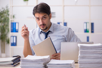 Young businessman employee unhappy with excessive work in the of