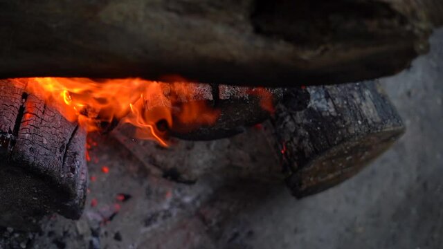 Bright orange color flame with flying particles at campsite bonfire