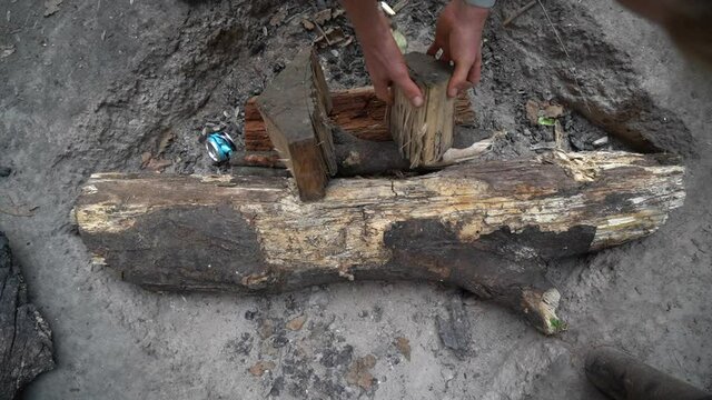 Person putting firewood to prepare campsite bonfire, close up view