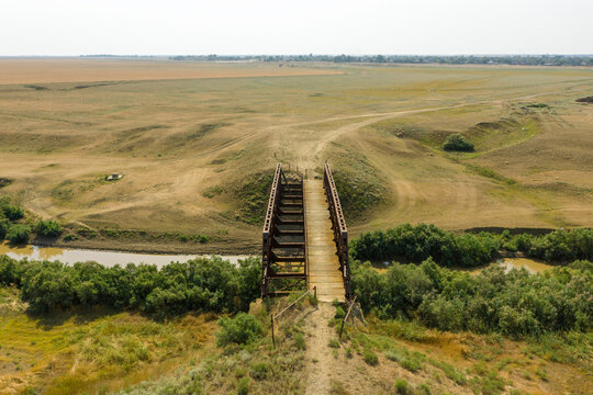 an old iron bridge over a river in the steppe on a country road a picture from a drone