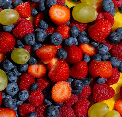 Fresh fruit salad. Grapes, blueberries, raspberries and strawberries. View from the top. Background of healthy fresh fruits. Summer time