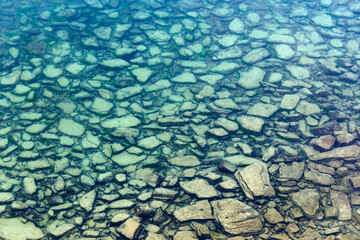 Background of transparent sea water and bottom with stones