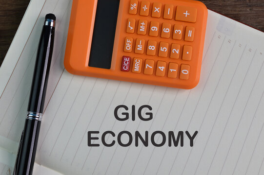 Pen, Calculator And Notebook Written With Text GIG ECONOMY