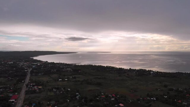 Aerial drone shot in the afternoon, sunset of the land from northern Cebu. Visible sky and clouds with hue of the sun setting. Peaceful sea, ocean and beautiful shoreline. The place is a tourist spot.