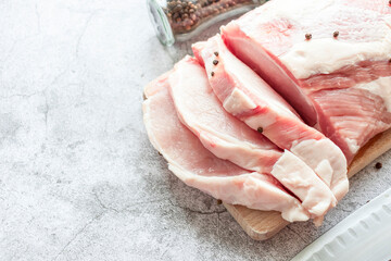 Piece of raw pork on a gray background. Fresh meat is ready to cook. view from above