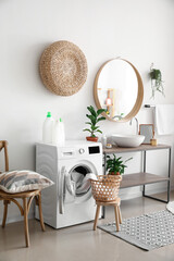 Interior of bathroom with modern washing machine