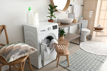 Interior of bathroom with modern washing machine