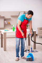 Young male contractor cleaning the house
