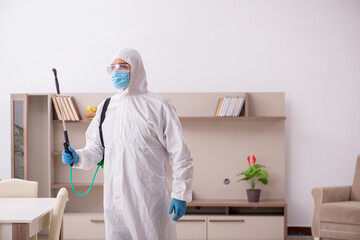 Young male contractor disinfecting at home